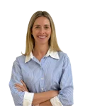 IMG_3958 Background Removed - Perfect Balance Rehabilitation Centre Smiling woman with blonde hair, wearing a blue and white striped shirt, arms crossed, against a dark background.
